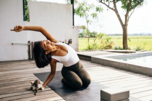 Frau führt mit Freude eine Yoga Übung aus