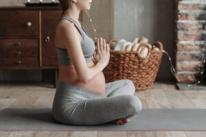 Schwangere Frau führt Yoga Übung aus